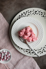 Delicate pink cake on a table with light dishes. Red currant tiramisu.