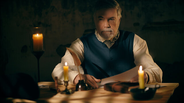 An 18th century man ponders a document he has been reading.