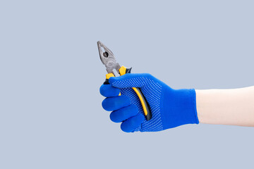 handyman repair minimal concept. worker holding pliers tool isolated over gray background