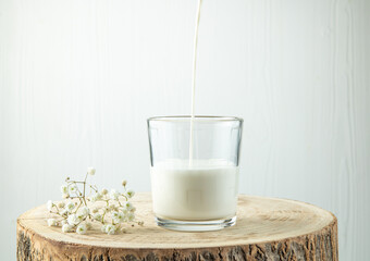 milk pouring into glass on old wooden table