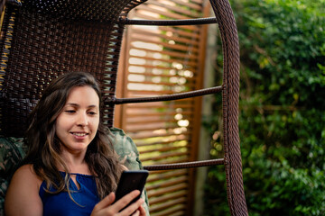Woman using mobile phone and relaxing near the nature