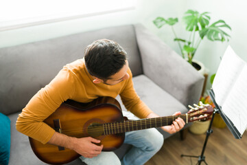 Good-looking guy playing the guitar at home