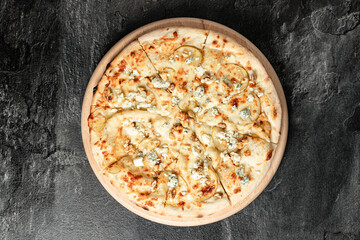 Hot tasty traditional italian pizza with salami, meat, cheese, tomatoes greens on a dark background