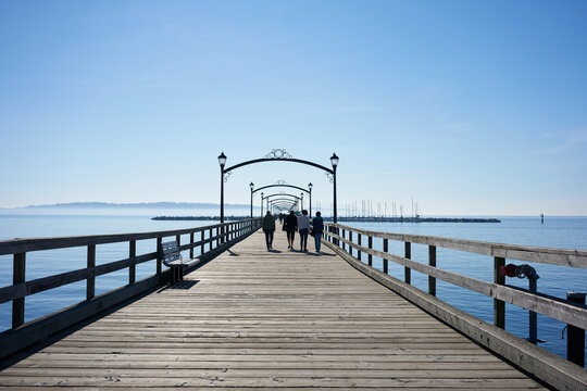 Family walking on the White Rock pier during a sunny spring day. 