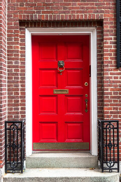 Close up of a traditional red wooden front door of a traditional brick house. Boston, MA, USA.