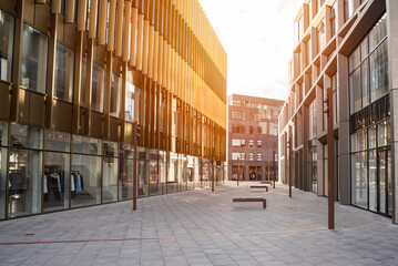 Deserted pedestrian street lined with modern buildings with shops on ground level in a shopping...