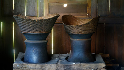 Traditional kitchen with firewood. There are two clay pans and a bamboo steamer on top. Classic kitchen of Indonesia