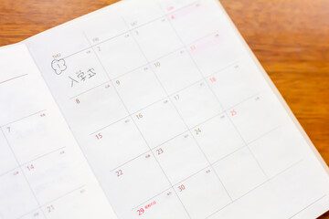 スケジュール帳に4月の入学式の予定を書く　春