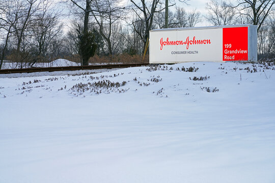 SKILLMAN, NJ -20 FEB 2021- View of a sign with the brand logo of Johnson and Johnson at the J&J Consumer Health division campus in Montgomery, New Jersey, United States, after a snowfall.