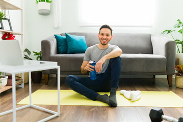 Fototapeta premium Young man resting on an exercise mat in the living room