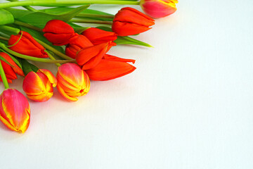A bunch of fresh yellow and orange tulip flowers on a wooden table