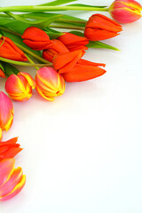 A bunch of fresh yellow and orange tulip flowers on a wooden table