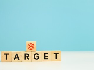 Target and focus concept. Phrase TARGET on wooden cubes isolated on blue background.