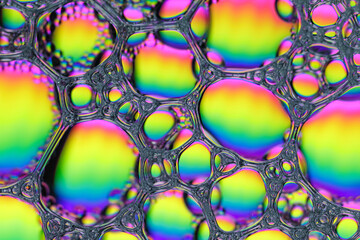 Bright Textural Foam Surface of Soap or Shampoo with Bubbles of Rainbow Gradient Colors.