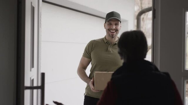 Opening the door for a courier delivering a package