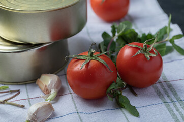 Fresh tomatoes with garlic and greens on a tablecloth