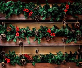 Fototapeta na wymiar Christmas decor of fir branches and red Rowan berries on a wooden background. The idea of Christmas decoration of the house, garden, cafe and restaurant.