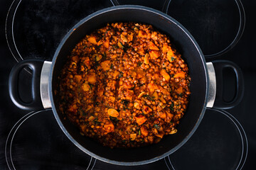 vegan pumpkin lentil and mushroom curry in pot on the stove, healthy plant-based food recipes