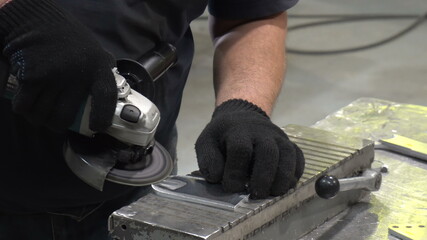 A man cleans the detail from deburring machine.