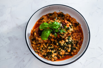vegan meatballs with tomato sauce and tiny pasta topped with basil and herbs, healthy plant-based food