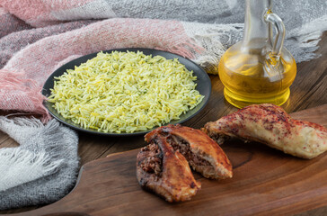 Grilled chicken and plate of rice on wooden table