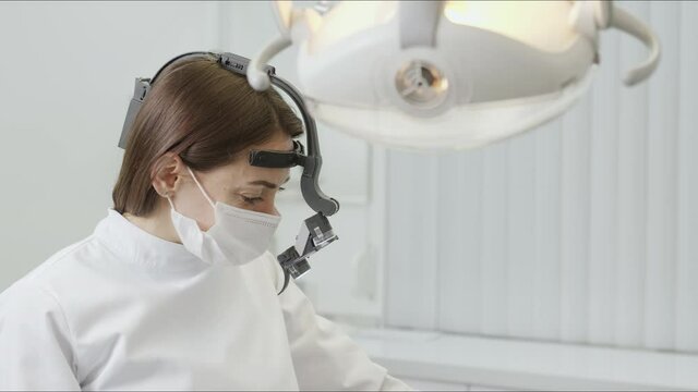 Happy doctor dentist take off the binocular glasses and smile. Hospital covid-19