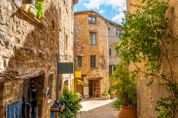Small shops on an ancient street inside the medieval walled stone village of Tourrettes Sur Loup in the Provence Alpes Maritimes area of South France.