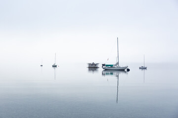 Fototapeta na wymiar Calm and peaceful boats in heavy fog on the ocean