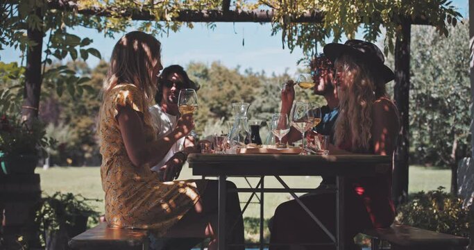 Nice-looking young friends eating and tasting wine