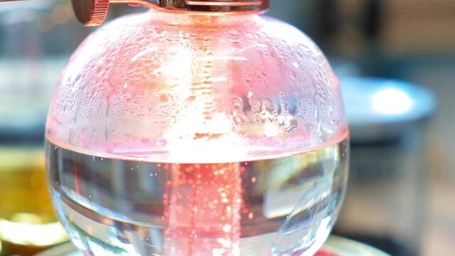 Beautiful coffee americano makes a barista in a gabe siphon in a cafe close-up, general plan