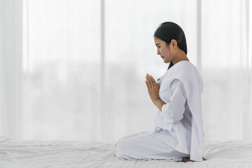 Religious Asian buddhist woman in white cloth praying and chanting