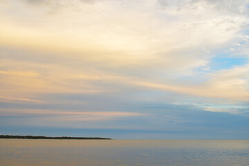 Obraz premium sunset colours in clouds reflected in waters of calm bay