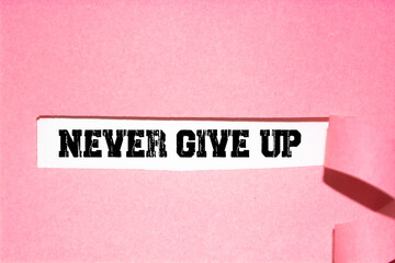 The text NEVER GIVE UP! appearing behind torn pink paper