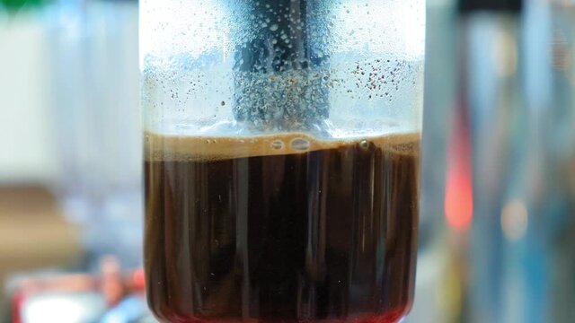 Beautiful coffee americano makes a barista in a gabe siphon in a cafe close-up, general plan