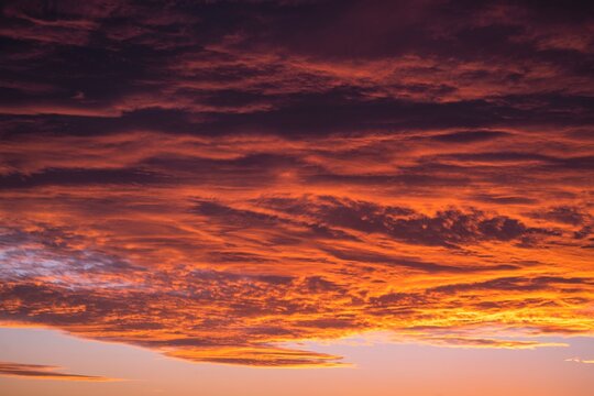 This image shows a vast sunset sky filled with large clouds. 