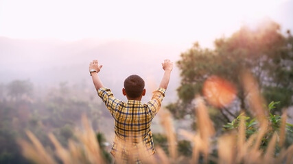 Boy arms raised to pray and worship God in the evening sunset. Young Christian concept.