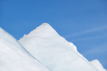 Fototapeta na wymiar Ice pyramids on blue sky background.