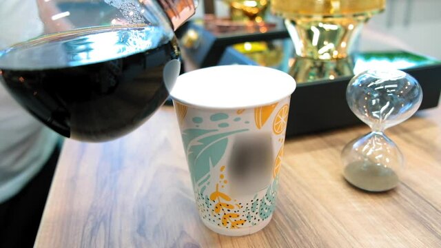 Beautiful coffee americano makes a barista in a gabe siphon in a cafe close-up, general plan