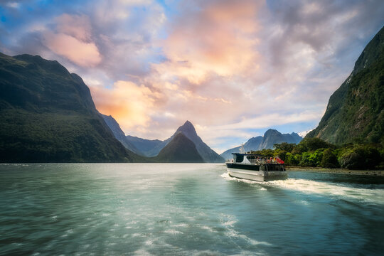 A Cruise going into Sunset at Milford Sound, a fiord in the southwest of New Zealand&rsquo;s South Island. Milford Sound is a fusion of spectacular natural features, rainforests, and waterfalls.