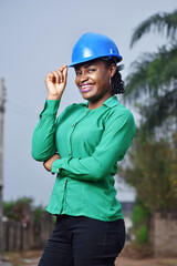 A Nigerian female construction and architectural engineer with blue safety helmet  