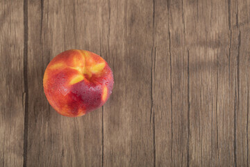 Yellow redish peach on a wooden deck