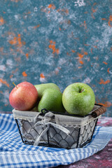 Apples in a mini metallic basket with a towel inside