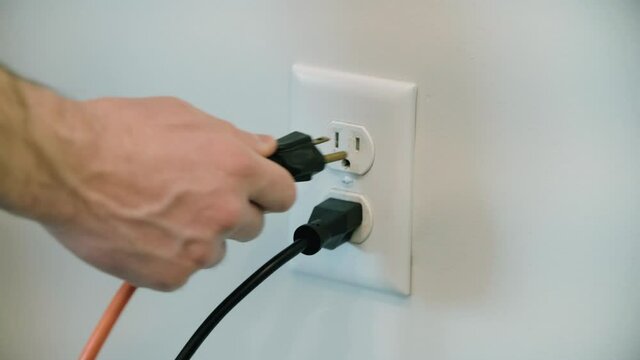 Extension Cord plugged into an electrical outlet in the wall several times. 