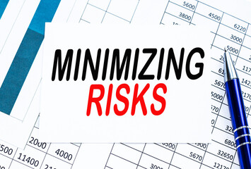 Text MINIMISING RISK on financial tables, the working paper . Business and financial conzept.