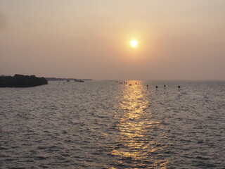 The morning sun rises where tourists are popular to come to visit the sea temple and see the local fishermen lifestyle next to the sea