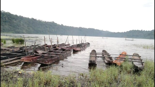 rows of wooden boats on the shore of a beautiful lake