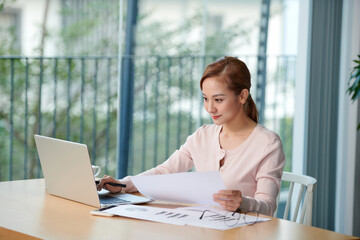 Portrait of a young business woman using laptop at office