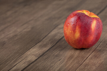 Red yellow peach isolated on a wooden table