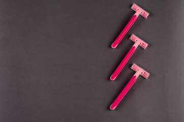 Red plastic razors on a gray background.
