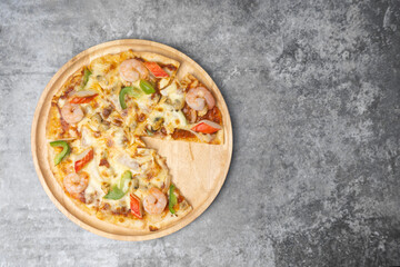 Top view Slices of seafood pizza on wooden plate.